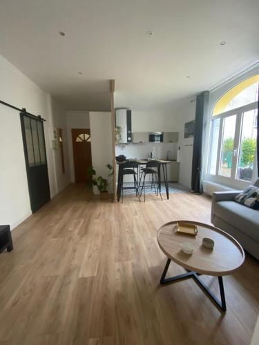 un salon avec un canapé et une table dans l'établissement charmant 2 pièces, à Cormeilles-en-Parisis