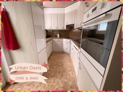 a kitchen with white cabinets and a sign that reads urban oasis cook and bake at Urban Oasis Basel - Cozy, Eco-friendly and Modern Apartment with Terrace & Garden in Allschwil