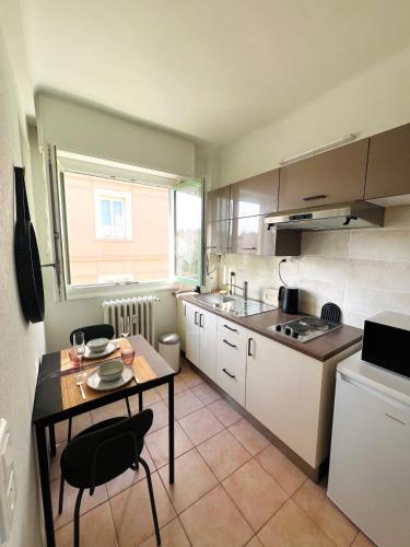 une petite cuisine avec une table et une table et des chaises dans l'établissement Central Menton Beach Retreat, à Menton