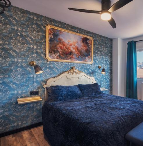 a bedroom with a bed and a painting on the wall at Apartamento 951 in Granada