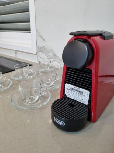 a red toaster sitting on a counter with empty glasses at kikar natanya in Netanya