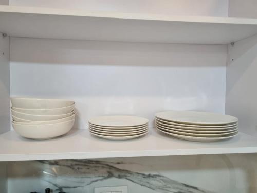 four plates and bowls are sitting on a shelf at kikar natanya in Netanya