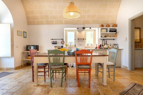 una cucina e una sala da pranzo con tavolo e sedie di Apulia Trulli Macco Macco Locorotondo a Locorotondo