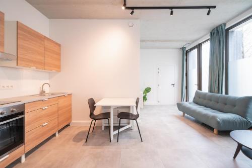 a kitchen and living room with a table and a couch at Opera Apartments in the Center of Antwerp in Antwerp