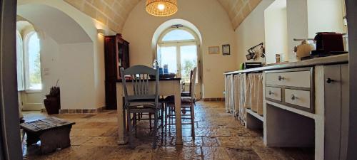una cucina con un tavolo e sedie in una stanza di Apulia Trulli Macco Macco Locorotondo a Locorotondo