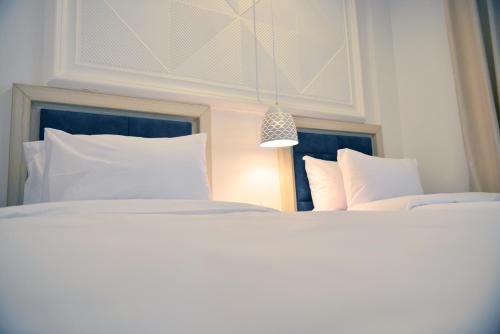 a bedroom with two beds with white pillows at Petra Karam Hotel in Wadi Musa