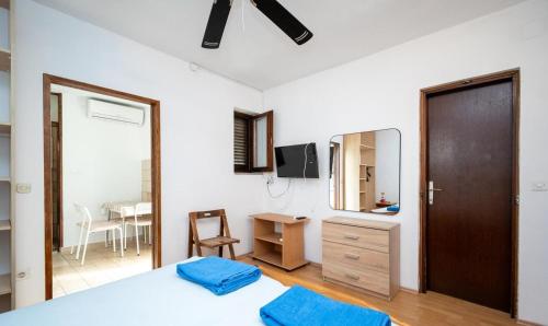 a bedroom with a bed and a mirror and a table at apartmani Nik in Bibinje