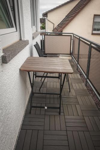 a wooden table and chairs on a balcony at Pension Nickel Ferienwohnung I Waldstraße 18 Alsbach-Hähnlein in Alsbach-Hähnlein