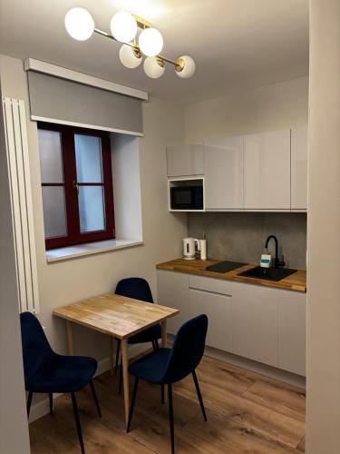 a kitchen with a wooden table and chairs and a table at PROVENIR HOME KWIATOWA 5 in Poznań