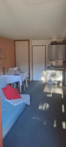 Cette chambre comprend 2 tables et un oreiller rouge. dans l'établissement Appartement calme, 6 pers, résidence la Barbade, à Les Deux Alpes