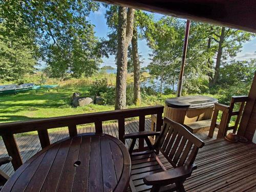 a wooden table and two chairs on a porch with a view at Holiday Village Anttoora - Anttooran Lomakylä in Pori