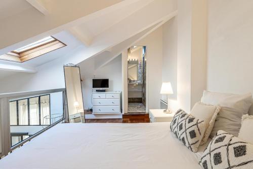 une chambre avec un lit blanc et un miroir dans l'établissement 13 ANDRE2 - Very nice duplex apartment, 100m from La Croisette and beaches, à Cannes