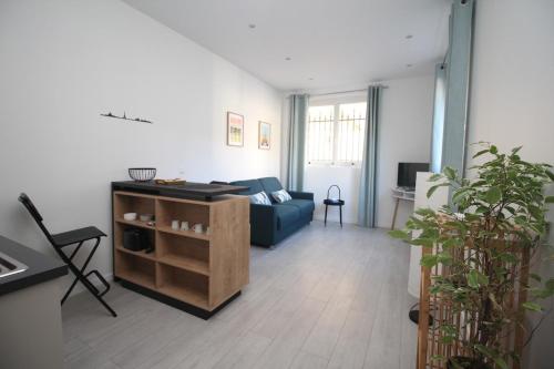 un salon avec un canapé bleu et une table dans l'établissement Studio à Cormeilles-en-Parisis, à Cormeilles-en-Parisis