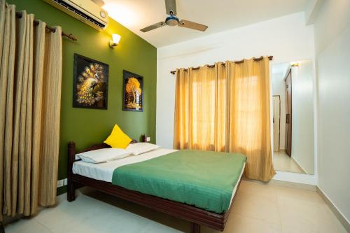 a bedroom with a bed with green walls at Orange valley Residency Thodupuzha in Thodupuzha