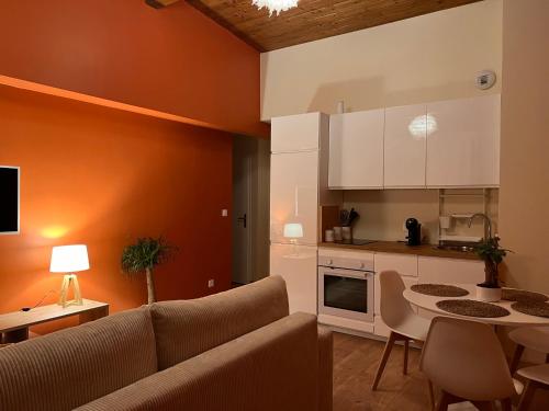 un salon avec un canapé et une cuisine dans l'établissement Appartement le cocon de terre, à Ambérieu-en-Bugey