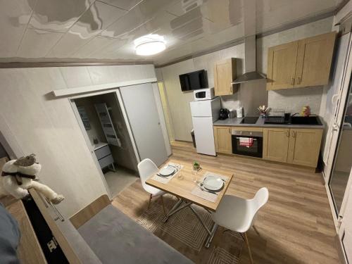 une petite cuisine avec une table et des chaises dans une pièce dans l'établissement Chambre d'Hôte de l'Etang, à Perrecy-les-Forges