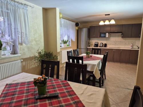 a kitchen and a dining room with tables and chairs at Noclegi u Agnieszki in Jarnołtówek