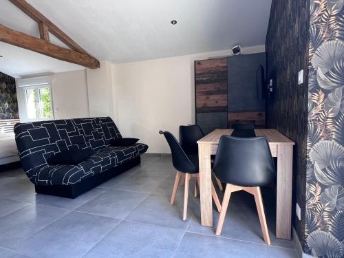 un salon avec un canapé, une table et des chaises dans l'établissement les gites du péré, à Soubise