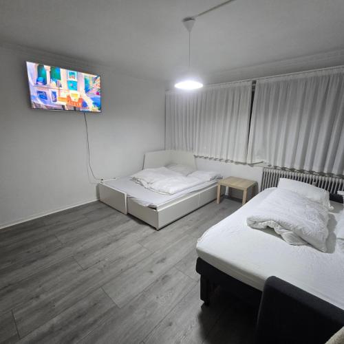a room with two beds and a flat screen tv at Jagersborg alle nice Flat in Gentofte