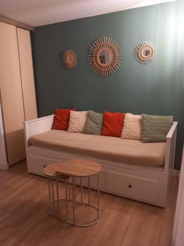 - un canapé avec deux miroirs et une table dans la chambre dans l'établissement Studio climatisé, une place de parking à la Faviére, à Bormes-les-Mimosas