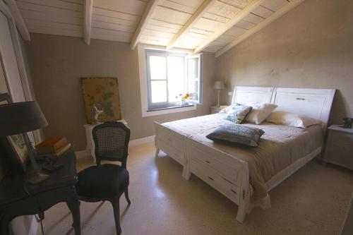 1 dormitorio con cama blanca y ventana en Casa Aquarela, en Cogorno
