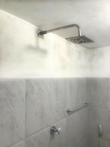 a bathroom with a shower with a light on the wall at Oneida Villa & Restaurant in Talpe