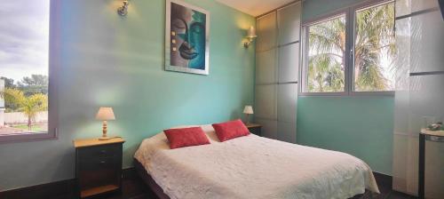 une chambre avec un lit avec deux oreillers rouges dans l'établissement Lovely villa with swimming pool for 6 people, à Fréjus