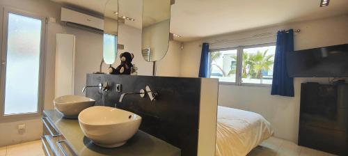 une salle de bain avec deux lavabos, un lit et une télévision dans l'établissement Lovely villa with swimming pool for 6 people, à Fréjus