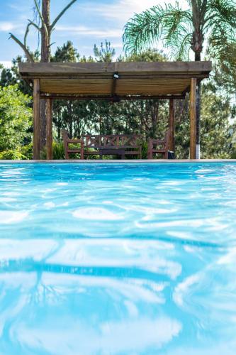 a swimming pool with a gazebo in the background at Pousada Mirante das Estancias in Águas de Lindóia