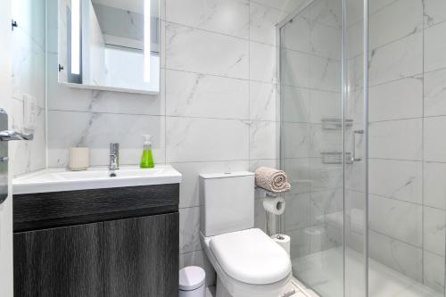 a white bathroom with a toilet and a shower at London 1 bedroom flat 5 min from station! in Kenton