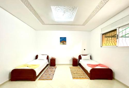 two beds in a room with a ceiling at Ocean Bliss Appartement in Agadir