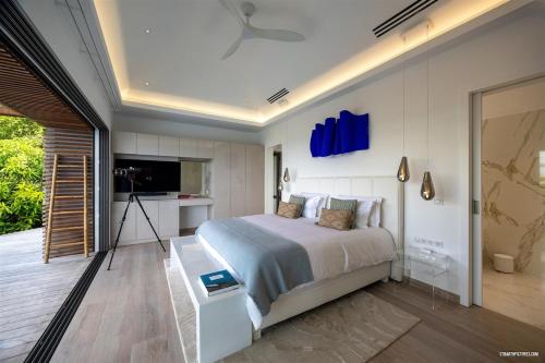a bedroom with a bed and a television in it at Villa neuve à Lurin avec vue mer sunset à proximité de Gustavia in Gustavia