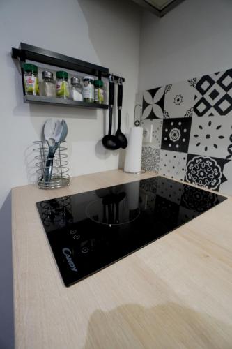 - un comptoir de cuisine avec un comptoir noir et blanc dans l'établissement STUDIO RENOVE RDC TERRASSE + EXTERIEUR PAYSAGE, à Grézieu-la-Varenne