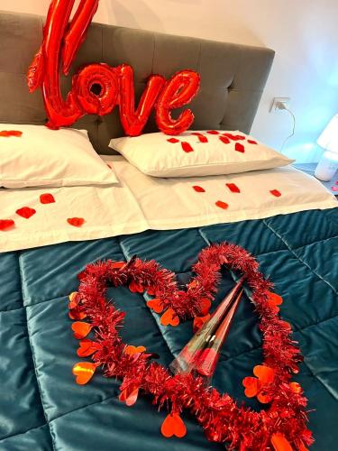 a bed with a heart wreath and a love sign at Dodi's house in Pozzuoli