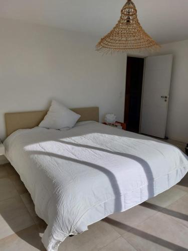 une chambre avec un lit avec une couette blanche dans l'établissement Haut de Villa - Corsica, à Lecci