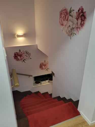 a staircase with a red carpet and flowers on the wall at Villa Vino & Grad in Zagreb