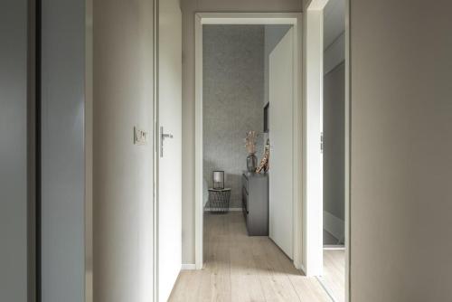 a hallway with white walls and a table in a room at Het Steven van Grou - luxury wellness house with hot tub in Grou