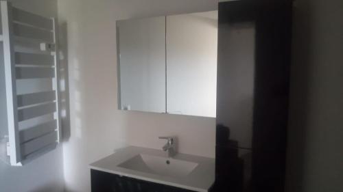 a white bathroom with a sink and a mirror at La vie en Rosans - The house in Saint-André-de-Rosans