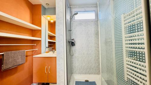 une douche avec une porte vitrée dans une salle de bain dans l'établissement L'escapade au coeur de Berck-sur-mer, à Berck-sur-Mer