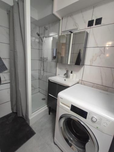 une machine à laver dans une salle de bain avec douche dans l'établissement Tout équipé en hyper centre, à Martigues