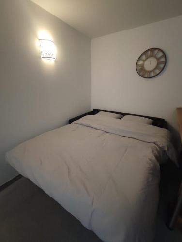 une chambre avec un lit et une horloge au mur dans l'établissement Tout équipé en hyper centre, à Martigues