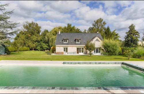 une maison avec une piscine devant une maison dans l'établissement Villa jardin piscine privée, à Saint-Étienne-la-Thillaye