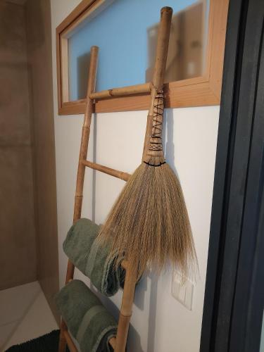 a broom hanging on a wall next to a window at L'Olivet in Sablet