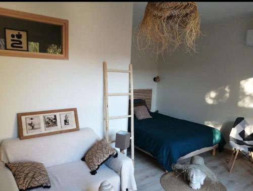 a bedroom with a bed and a chair and a ladder at L'Olivet in Sablet