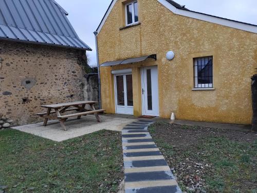 a picnic table and a bench in front of a building at maison au calme in Lanne