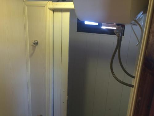 a bathroom with a toilet with a light on the wall at The Shark in Punta Del Diablo