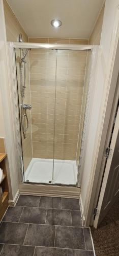 a shower with a glass door in a bathroom at Sun Gardens Retreat- can sleep 10 with 4 Double Beds & 2 sofa beds in Stockton-on-Tees