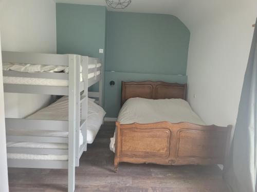 a bedroom with two bunk beds and a ladder at Gîte La nouette in Plémet