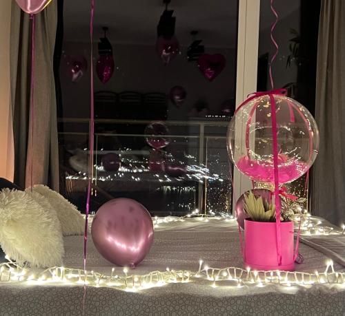 a room with pink balloons and lights on a table at MIŁOŚĆ ma swój adres - ZMYSŁOWE apartamenty z JACUZZI dla Dwojga in Ełk