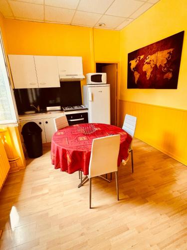 une cuisine avec une table et des chaises dans une pièce dans l'établissement F1 Tulipe, à La Bourboule